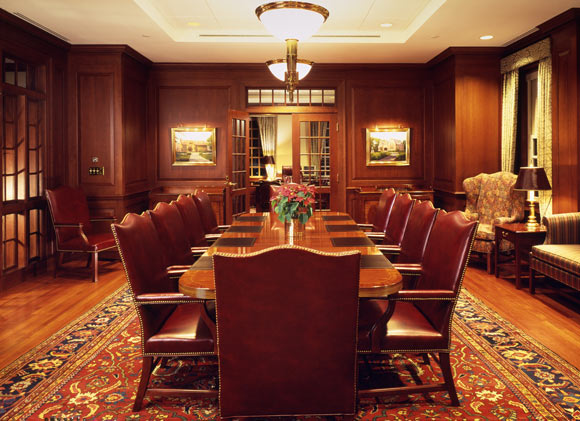 Quincy Mutuals elegant, all wood conference room with brown highbacked chairs, wood flooring and red and black area rug. = https://www.quincymutual.com/index.htm