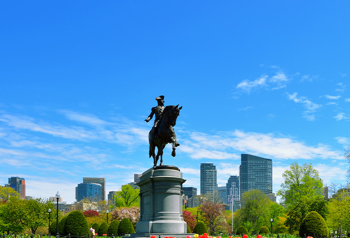 A panoramic view of the Public Garden in Boston, Massachusetts, featuring the iconic equestrian statue of George Washington. - www.quincymutual.com