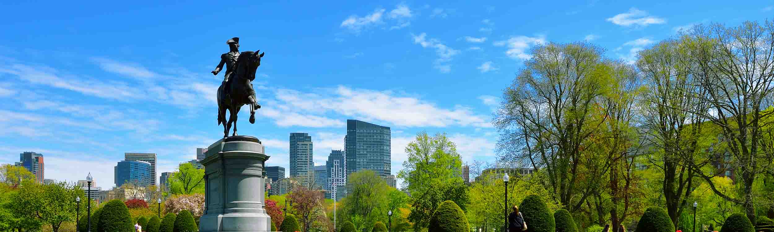 A panoramic view of the Public Garden in Boston, Massachusetts, featuring the iconic equestrian statue of George Washington. - www.quincymutual.com